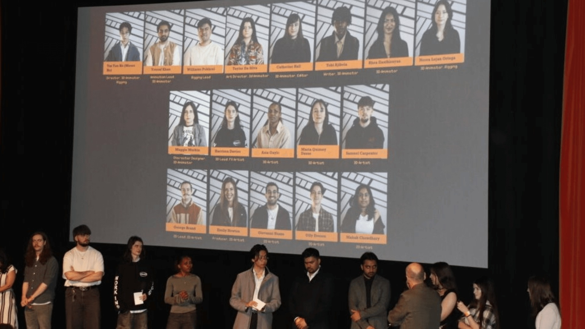 A group of students presenting on stage with a large screen behind them