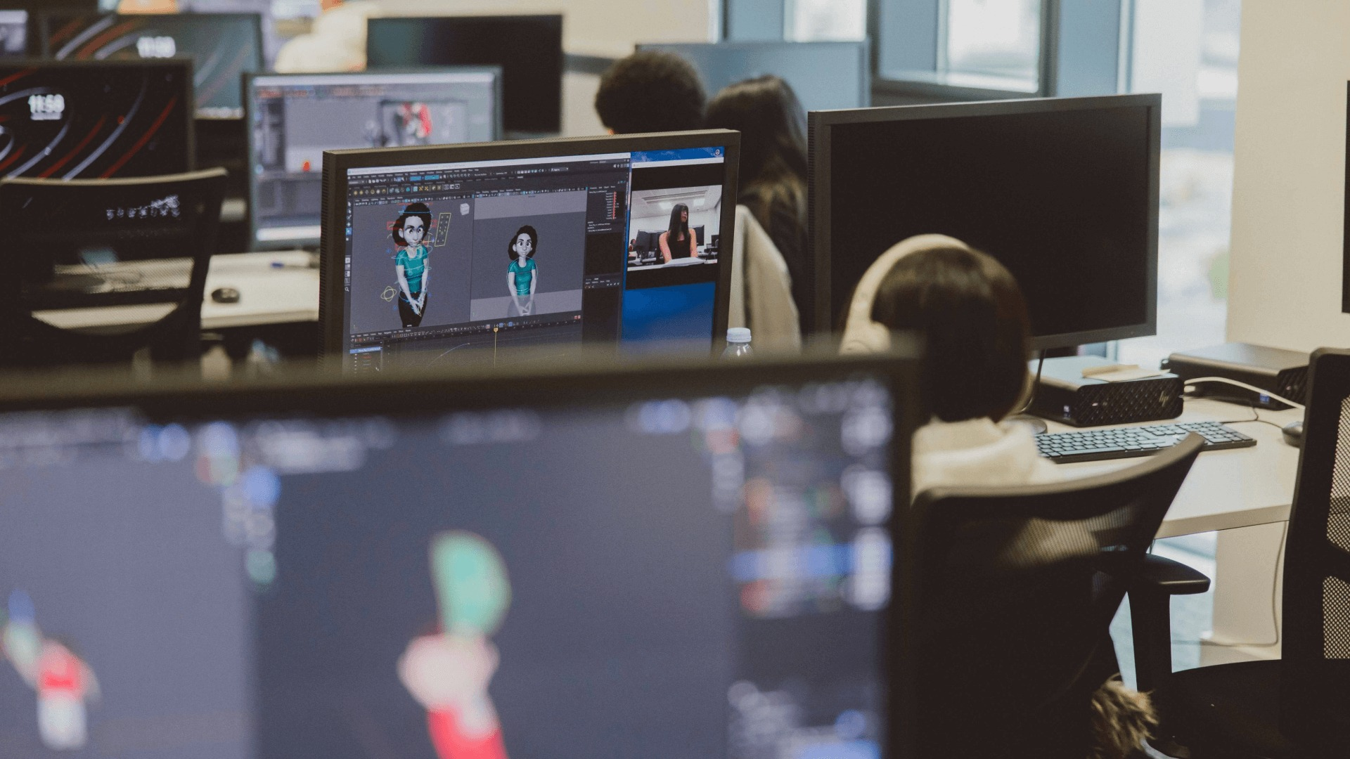 People working at computer stations with animation software on screens