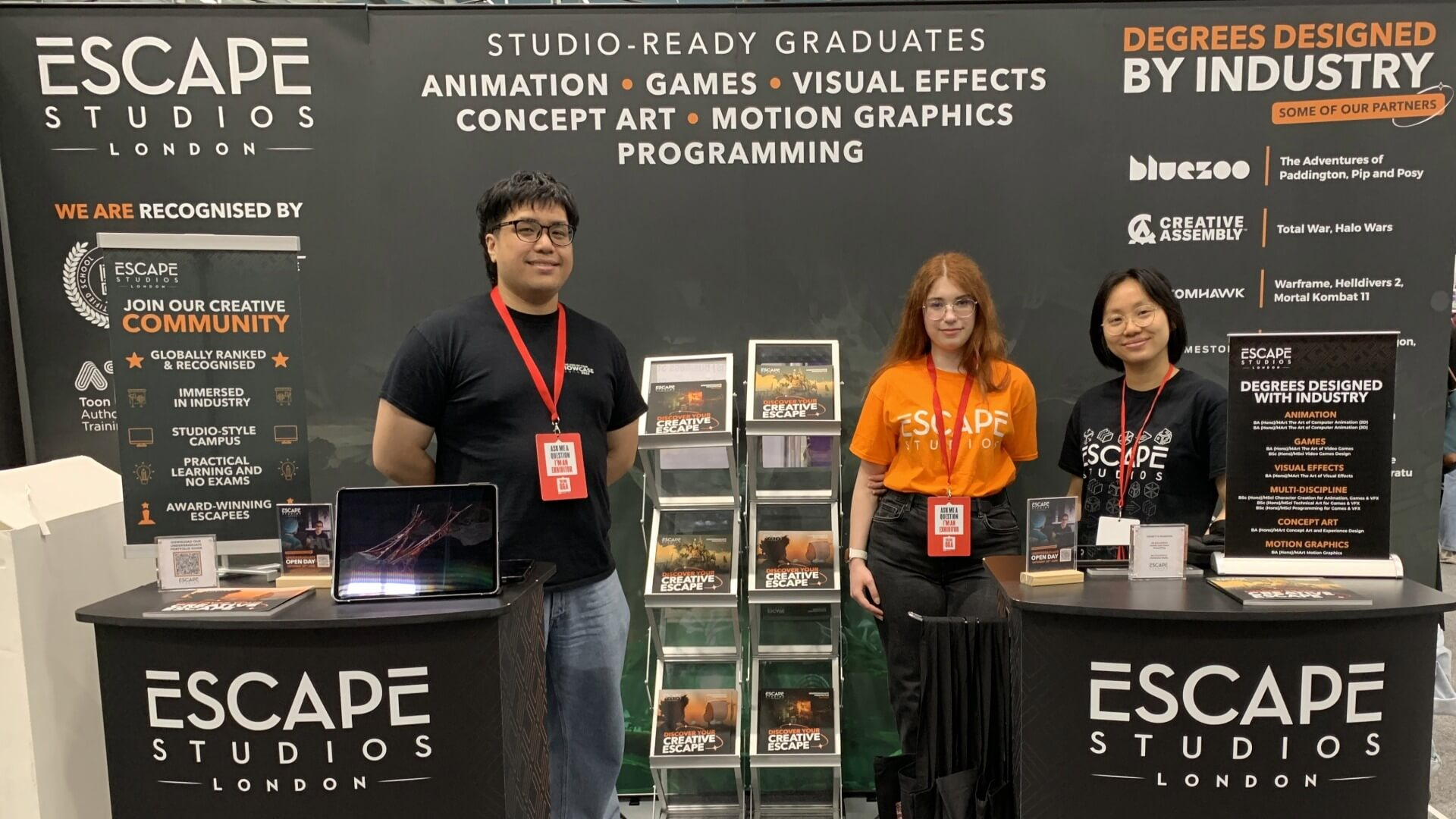 three staff members at an Escape Studios stall at a higher education exhibition event